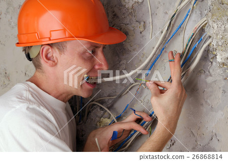 Worker electrician teeth compresses dangling wires Worker electrician teeth compresses dangling wires 26868814