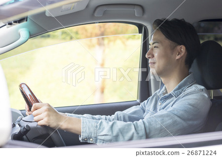 A young man driving a car 26871224