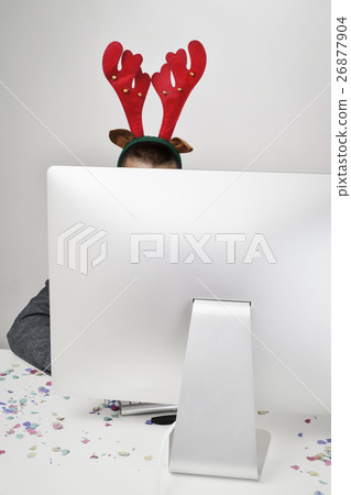 man with reindeer antlers headband in his office 26877904