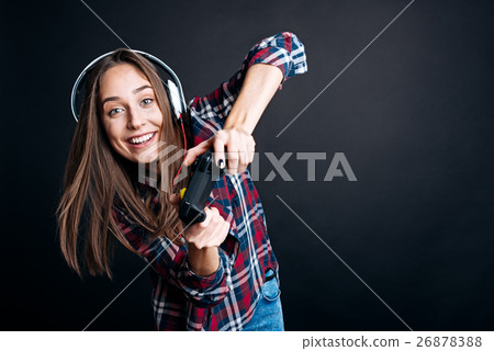 Positive young woman holding game console 26878388