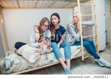 Beautiful girls sitting on a bed in hostel talk 26880611