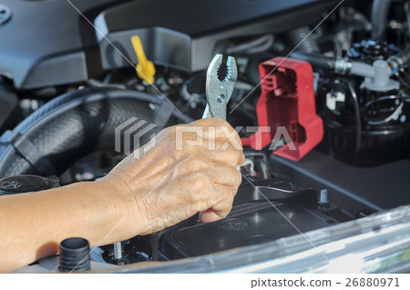 Elderly woman repairing her car 26880971