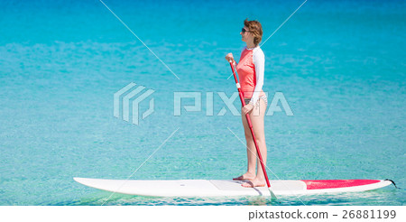 woman stand up paddling woman stand up paddling 26881199