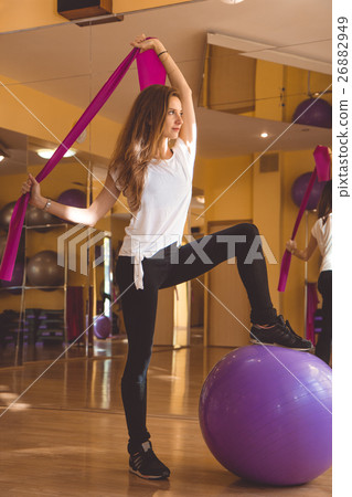 Slim pretty woman with purple fitball in gym Slim pretty woman with purple fitball in gym 26882949