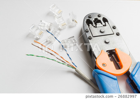 Crimper, connectors and ethernet cable on white  26882997