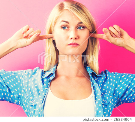 A woman who is blocking her ears 26884904