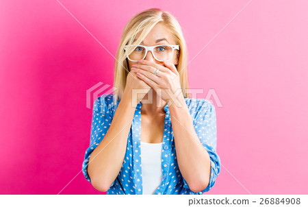 A woman holding her hand on her mouth A woman holding her hand on her mouth 26884908