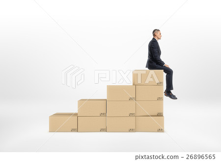 Businessman sitting on top of closed cardboard 26896565