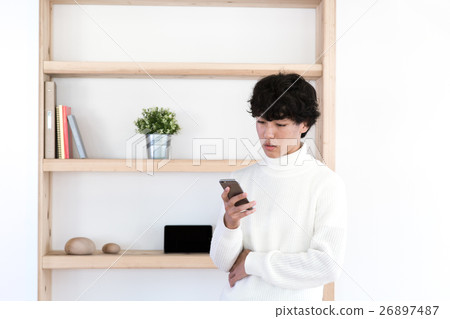 A young man operating a smartphone A young man operating a smartphone 26897487