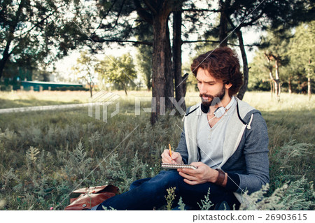 Man writing in copybook at nature, free space Man writing in copybook at nature, free space 26903615