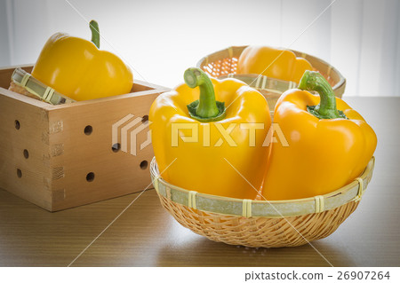 Fresh yellow bell peppers in basket 26907264