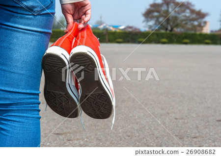woman hand holding a red sneakers. 26908682