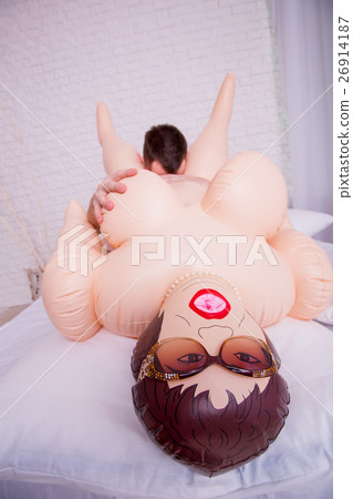 Naked man playing with inflatable sex doll. 26914187