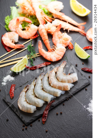 Raw and boiled shrimps on a stone plate 26914434