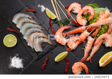 Raw and boiled shrimps on a stone plate Raw and boiled shrimps on a stone plate 26914471