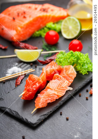 Raw salmon skewers on a stone plate Raw salmon skewers on a stone plate 26914495