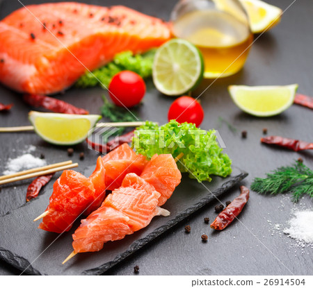 Raw salmon skewers on a stone plate. Raw salmon skewers on a stone plate. 26914504