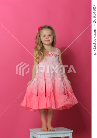 Little lady in dress standing on chair. Pink 26914907