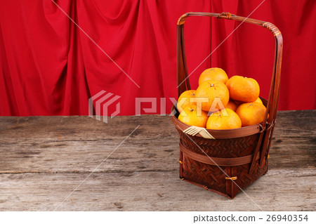Basket of mandarin oranges on wooden surface Basket of mandarin oranges on wooden surface 26940354
