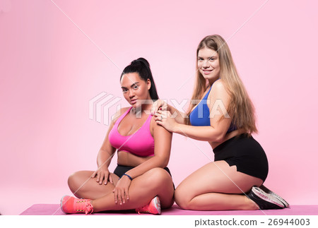 Two chubby women sitting on floor Two chubby women sitting on floor 26944003