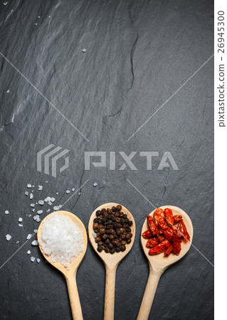 spices in wooden spoons over black background spices in wooden spoons over black background 26945300