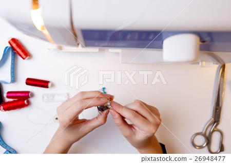 Woman fill bobbin sewing machine Woman fill bobbin sewing machine 26948477