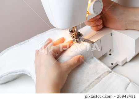 Woman starts tailoring on sewing-machine Woman starts tailoring on sewing-machine 26948481