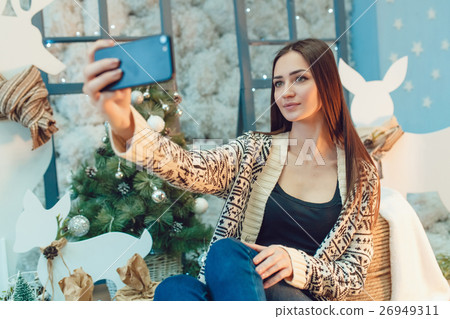 Beautiful young woman sitting on the background of 26949311