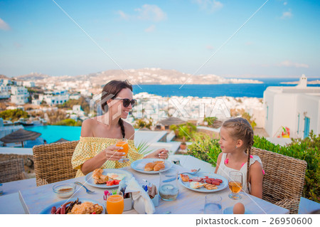 Family having breakfast at outdoor cafe with 26950600