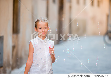 Adorable little girl outdoors blowing soap bubbles 26950753