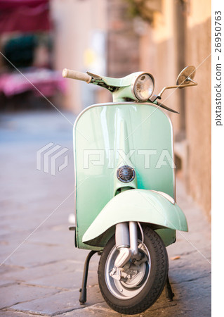 Light blue scooter on the street of the old city 26950763