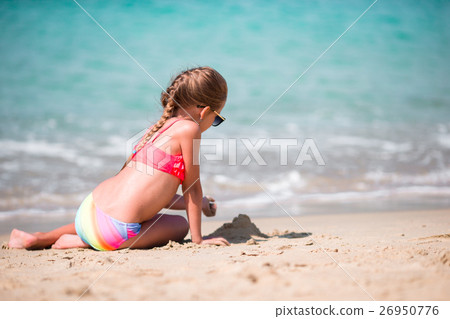 Adorable little girl drawing on sand at beach Adorable little girl drawing on sand at beach 26950776