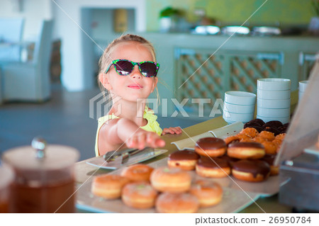 Adorable little girl having breakfast at cafe Adorable little girl having breakfast at cafe 26950784