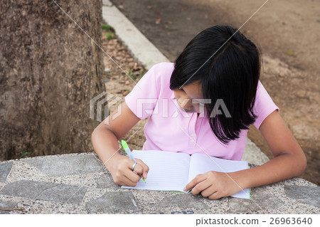 cute girl writing book in the garden 26963640