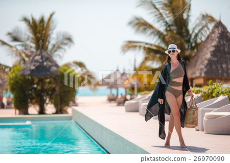 Beautiful young woman relaxing near the swimming 26970090