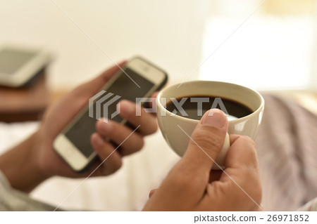 young man with a coffee using a smartphone 26971852