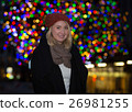 Beautiful young woman with christmas tree in the background 26981255