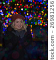 Beautiful young woman with christmas tree in the background 26981256