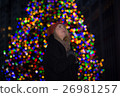 Beautiful young woman with christmas tree in the background 26981257