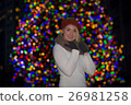 Beautiful young woman with christmas tree in the background 26981258