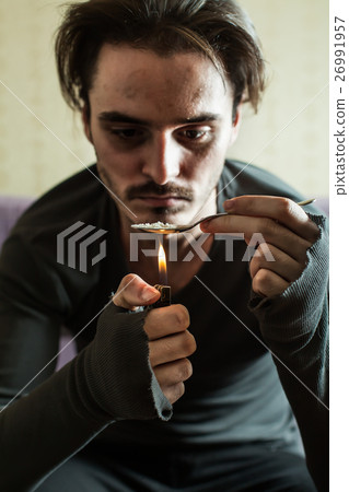 Addict in depression preparing dose of heroin. Addict in depression preparing dose of heroin. 26991957
