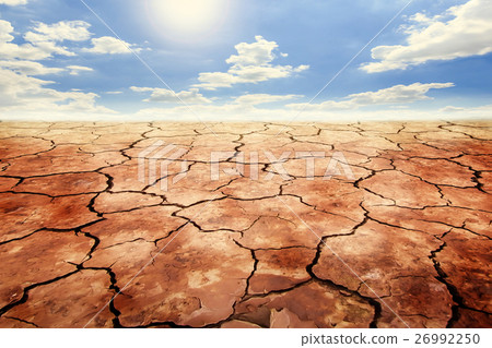 Dry cracked soil in drought land under blue sky. Dry cracked soil in drought land under blue sky. 26992250