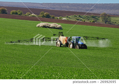 Tractor spraying field, rural landscape in country Tractor spraying field, rural landscape in country 26992695