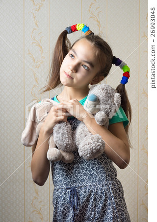 girl with two soft toys dreamily looking up 26993048
