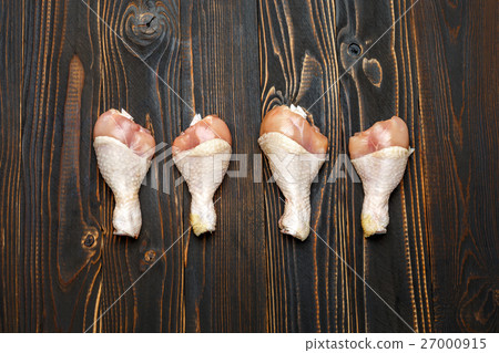 Raw chicken legs in baking dish on a wooden 27000915