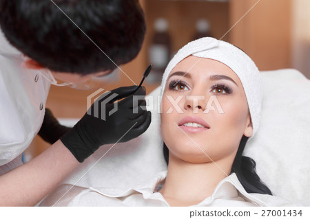 Beautiful young woman gets eyebrow correction 27001434