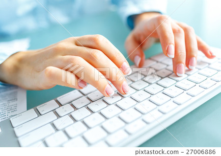Woman office worker typing on the keyboard Woman office worker typing on the keyboard 27006886