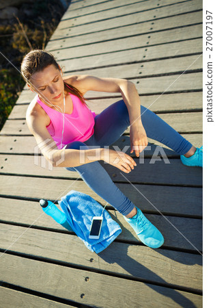 Athletic woman resting after running at morning Athletic woman resting after running at morning 27007197