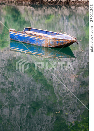 Boat floating on calm lake water Boat floating on calm lake water 27011268