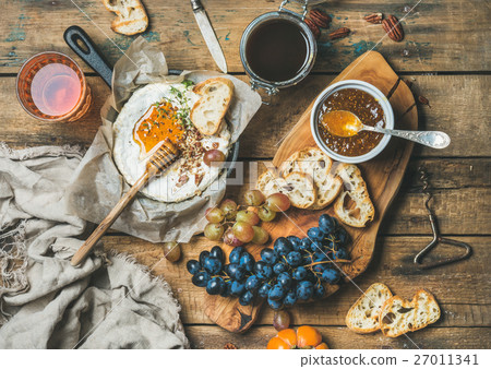Cheese, fruit, nut and wine set over rustic wooden 27011341